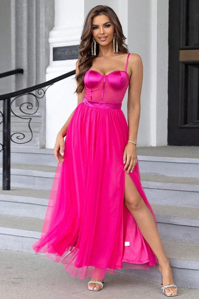 woman wearing a floor-length bright pink tulle formal dress with a satin bodice and high leg slit