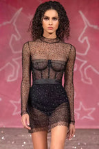 Model wearing a black embellished mesh mini dress on a runway