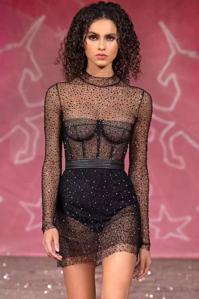 Model wearing a black embellished mesh mini dress on a runway