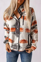 Woman wearing a cream fleece jacket with an orange, black, and grey geometric print, featuring a snap button front and stand collar.