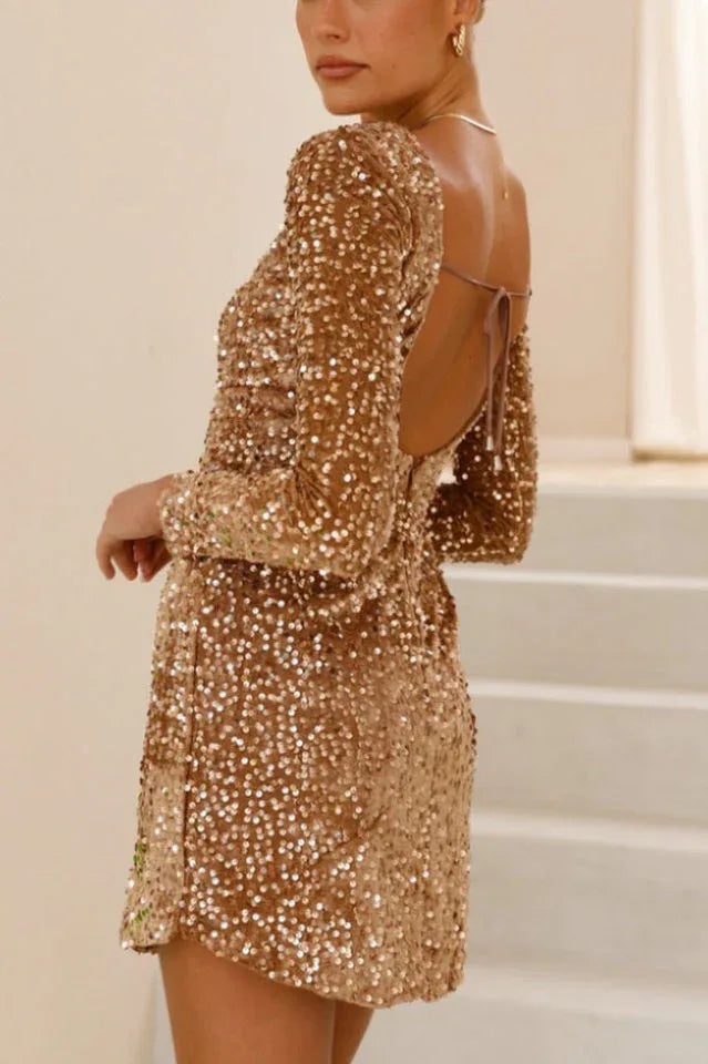 Woman wearing a gold sequin mini dress with long sleeves and an open back Main image