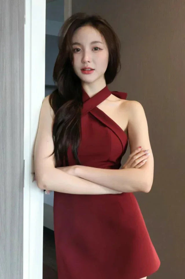 Woman posing in a red halter neck A-line mini dress with arms crossed