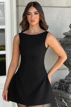 front view of a woman in a red mini dress with a square neckline and bow detailing on the straps