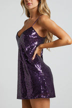 side view of a woman in a purple sequin mini dress