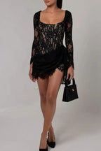 Full-body view of a woman in a black lace mini dress with a draped skirt.