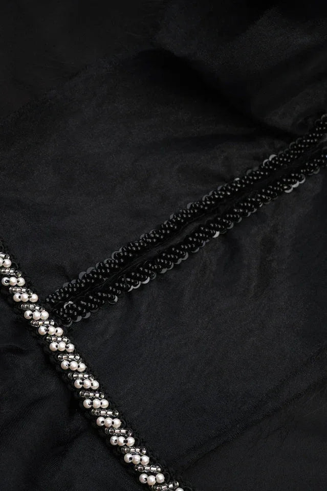 Close-up of beaded trim and sequin detail on black gown