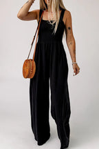 Close-up of the smocked bodice and square neckline of a black jumpsuit