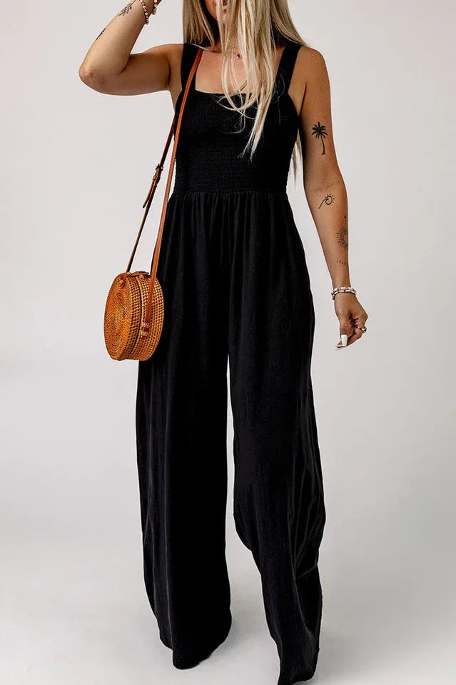 Close-up of the smocked bodice and square neckline of a black jumpsuit