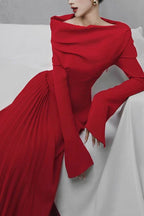 Model wearing a red off-the-shoulder gown with draped bodice and bell sleeves