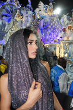 Woman wearing a hooded metallic mesh garment at a festive event.