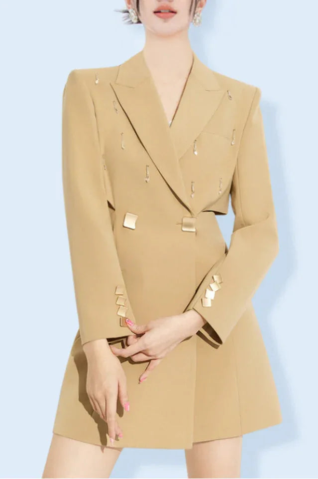 Woman wearing a tan double-breasted blazer dress with cut-out details and decorative embellishments Main image
