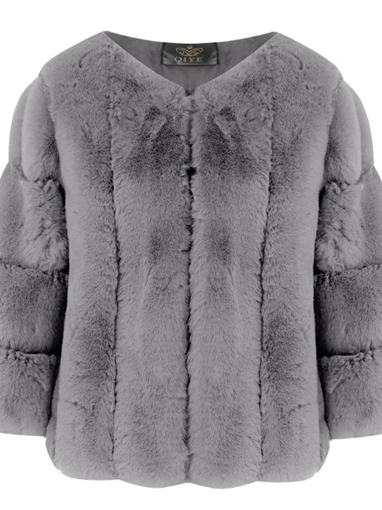 Close-up of a grey faux fur jacket with a textured sleeve design and a v-neck.