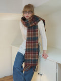 Woman posing with a long, plaid scarf draped around her neck.