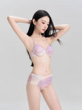 Woman wearing a lavender and peach tie-dye bikini with a sheer mesh cover-up