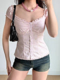 Close-up of a pink striped floral print top with a sweetheart neckline and button-down front.