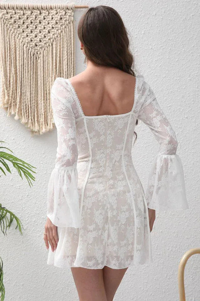 Back view of a woman in a white lace mini dress with bell sleeves.