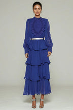 Woman wearing a royal blue tiered chiffon maxi dress with lace detail and balloon sleeves