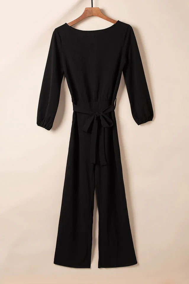 Black long sleeve wide leg jumpsuit with a tie waist, displayed flat.