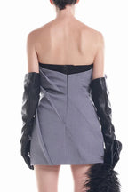 Back view of the grey strapless mini dress, showing a zipper closure and pleated detailing.
