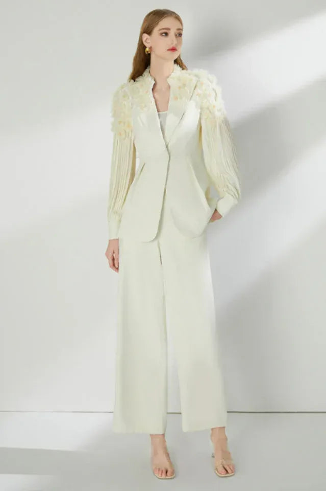 Woman wearing a cream-colored suit set with a blazer and wide-leg pants.