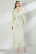 Woman wearing a cream-colored suit set with a blazer and wide-leg pants.