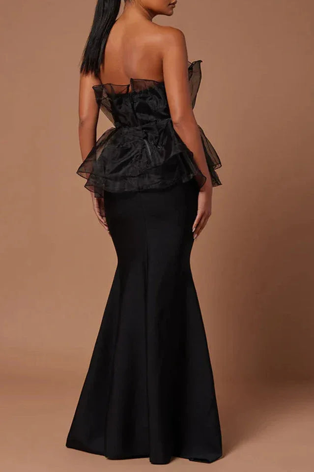 Back view of woman in black strapless formal dress with ruffled organza peplum and mermaid skirt