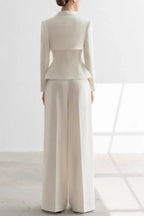 Woman wearing a white tailored suit set with a peplum jacket and wide-leg trousers, back view.