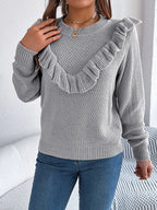 Close-up of the ruffle detail on a gray knit sweater