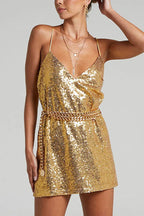 woman wearing a gold sequin mini dress with a gold chain belt and layered necklaces