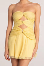 Close-up of yellow strapless dress bodice featuring ruching and crystal accents