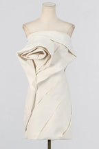 Mannequin displaying an off-white strapless mini dress with a dramatic rose-like floral accent.