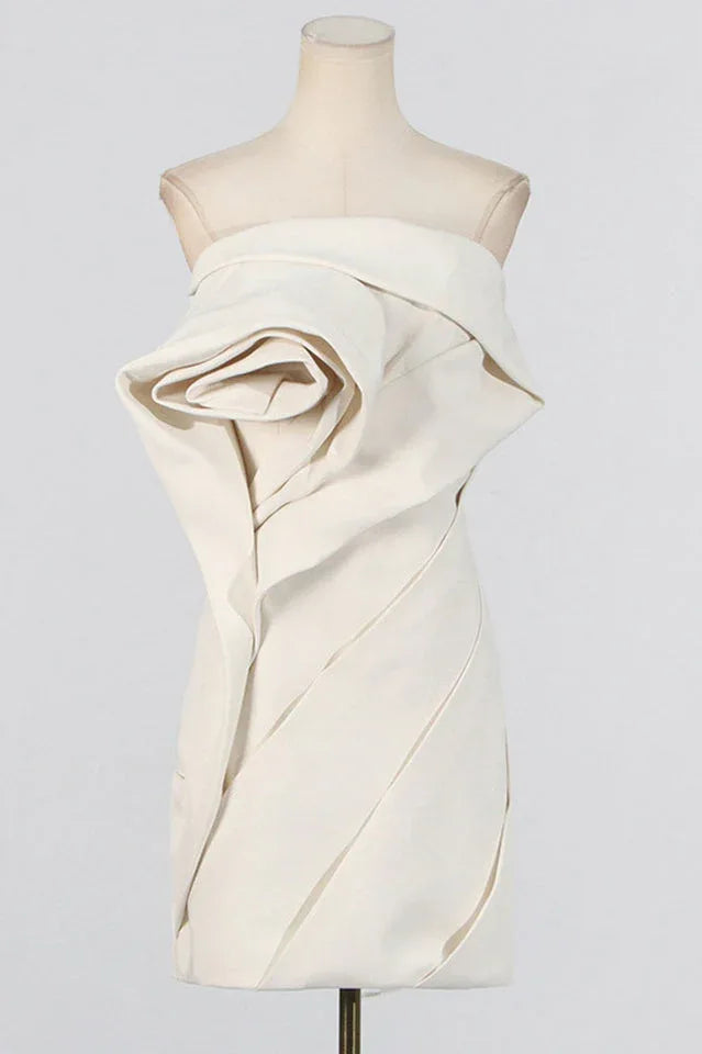 Mannequin displaying an off-white strapless mini dress with a dramatic rose-like floral accent.