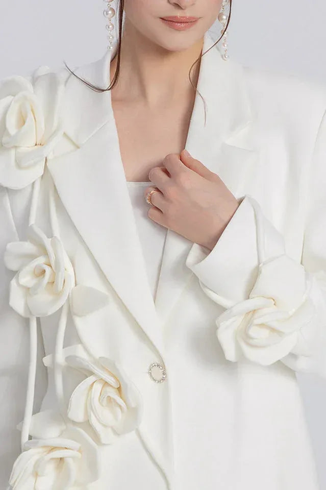 Close-up of the woman's chest area showing the blazer's lapel, floral details, and a ring.