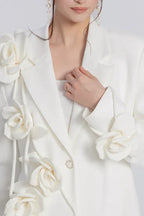 Close-up of the woman's chest area showing the blazer's lapel, floral details, and a ring.