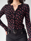 Front view of a fitted black cardigan with a repeating pink floral design.
