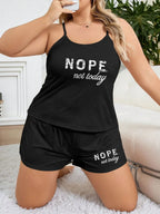 Woman in a black pajama set with a 'Nope, not today' graphic, posing in a bedroom setting
