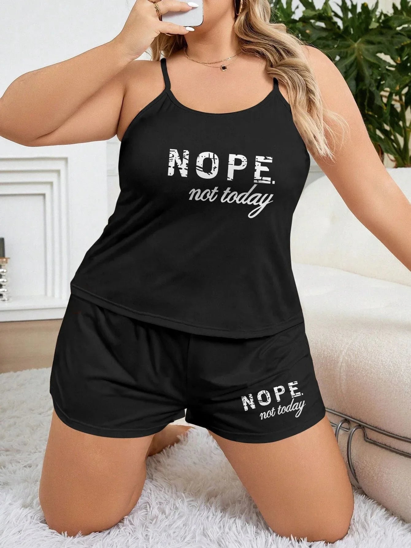 Woman in a black pajama set with a 'Nope, not today' graphic, posing in a bedroom setting