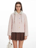 Close-up of the pink quilted jacket featuring embellished buttons and faux fur collar.