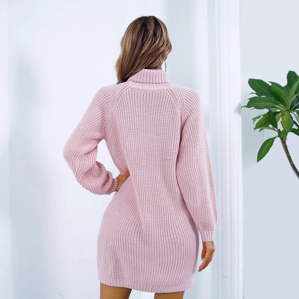 Woman wearing a pink knit turtleneck sweater dress with a black belt and sunglasses