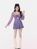 Woman in a purple ruched long-sleeve swim dress and cream boots, smiling