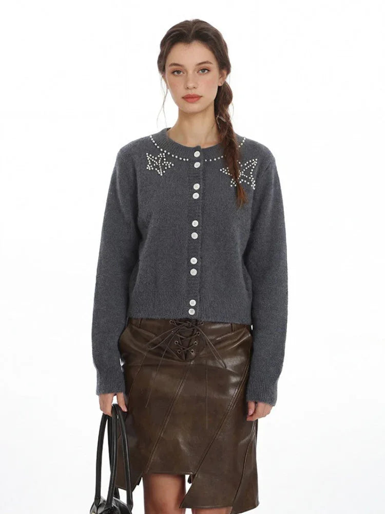 Close-up of the grey knit cardigan featuring a pearl-embellished neckline.