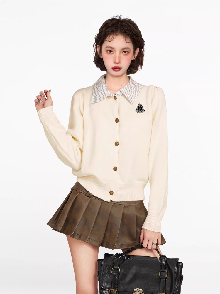 Woman wearing a cream-colored knit cardigan with a collared neckline and button-up front, paired with a brown pleated skirt.