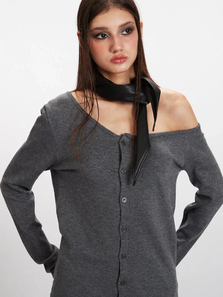 Detail shot of the grey knit cardigan's asymmetrical neckline and button-up front.