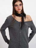 Detail shot of the grey knit cardigan's asymmetrical neckline and button-up front.