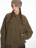 Close-up of the front of a brown herringbone bomber jacket with a stand collar and zipper.