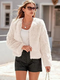 Woman wearing a white faux fur cropped jacket with black shorts.