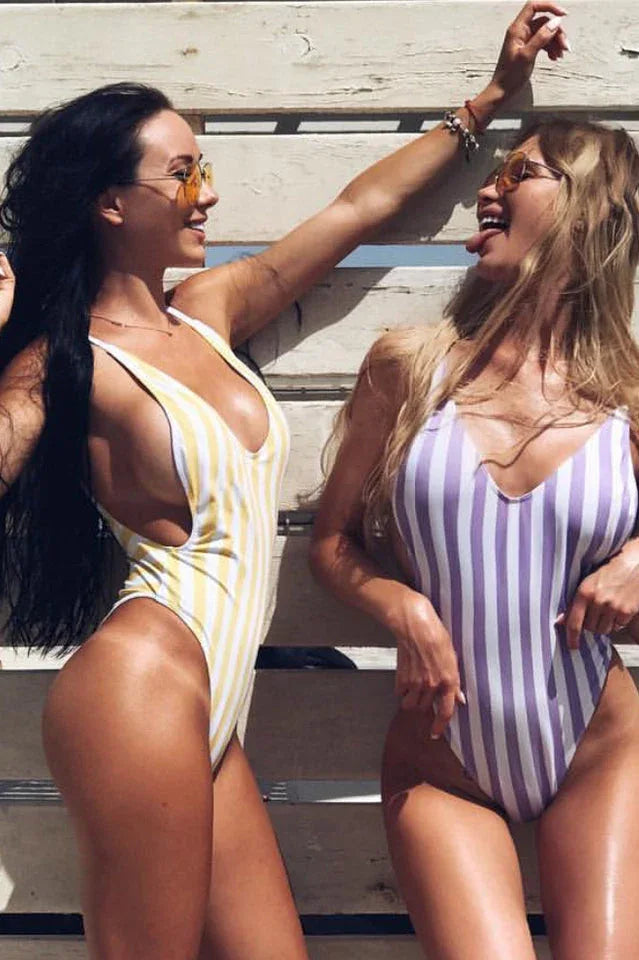 Two women wearing striped one-piece swimsuits