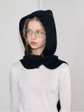 Close-up of a woman's face with a black knit hooded scarf