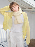Cream knitted scarf paired with yellow mesh cardigan and white outfit