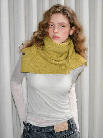 Model wearing yellow knitted scarf with button closure